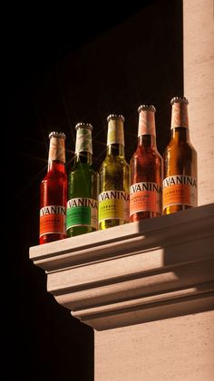 six bottles of beer are lined up on a shelf