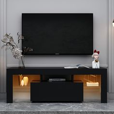 an entertainment center with a flat screen tv mounted on it's wall and two vases in front of it