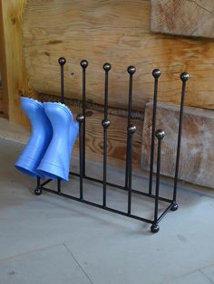 three blue napkins are sitting in a rack on the floor next to a wooden wall