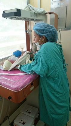 a woman in scrubs is operating on a machine