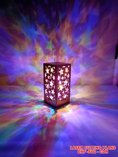 a lit up box sitting in the middle of a room with colorful lights on it