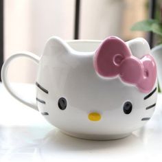 a hello kitty mug sitting on top of a table