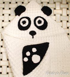 a crocheted panda bear hat on top of a white and black tile floor