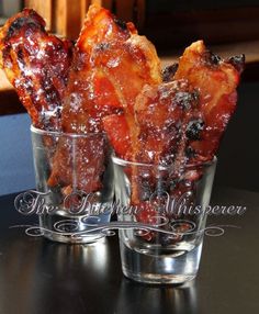 three glasses filled with food sitting on top of a black table next to each other