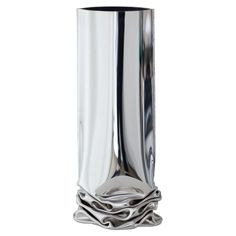 a tall silver vase sitting on top of a table