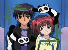 two anime characters standing next to each other in front of a blue wall with pandas on it