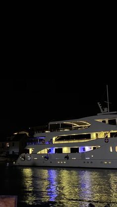 a large white boat in the water at night