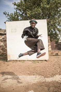 a man is jumping in the air with his hat on