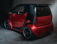 a small red and black car parked in a garage