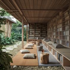 a room with many bookshelves and pillows on the floor in front of them