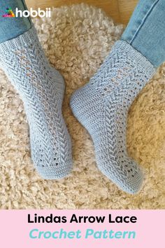 the legs and ankles of a woman wearing blue crocheted socks on a rug