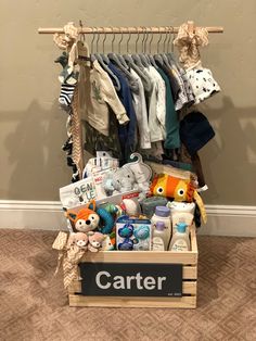 a wooden crate filled with baby items on top of carpeted floor next to wall