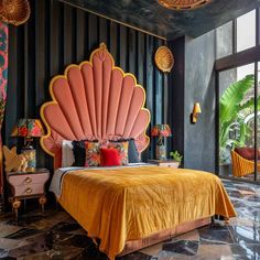 a bedroom with an orange bed and gold accents on the walls, along with black striped walls