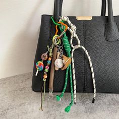 a black handbag with various items hanging from it's handles on a table