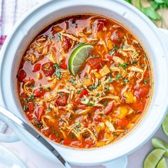 a white bowl filled with chicken tortilla soup and garnished with cilantro