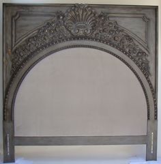 an ornate metal headboard is shown against a white wall with no sheets on it