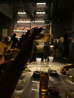 a person holding up a glass with some liquid in it