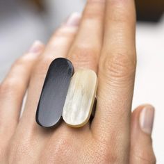 a woman's hand with a black and white ring on it