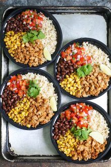 four black bowls filled with food on top of a pan covered in rice and beans