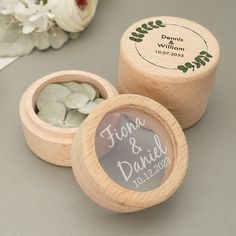 two wooden boxes with wedding favors in them on a table next to flowers and a bouquet