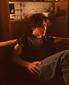 a man sitting on top of a couch in a living room