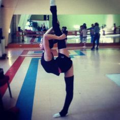 a woman is doing a handstand in the middle of a dance studio floor