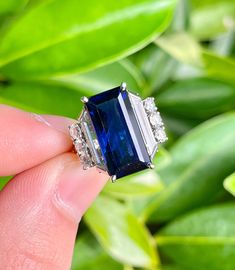 "Enjoy the sight of this magnificent Blue Sapphire and Diamond ring. This certified ring features a Blue Sapphire to die for! It radiates deep blue color hues (especially under sunlight) and bears zero clarity or color enhancements. Excellent cut and Emerald cut with mirror-like step facets executed to perfection. All made in beautiful art deco Euro ring shank. Another key component to this ring's value is in the Trapezoidal cut Diamond side stones. At 1 carat each, these VS1diamonds are of pris Blue Radiant-cut Emerald Ring In Fine Jewelry Style, Blue Radiant Cut Emerald Ring In Fine Jewelry, Blue Tanzanite Rings In Radiant Cut, Blue Radiant-cut Emerald Ring Fine Jewelry, Blue Radiant Cut Emerald Ring Fine Jewelry, Blue Baguette Cut Lab-created Sapphire Ring, Blue Gia Certified Emerald Ring For Formal Occasions, Fine Jewelry Blue Radiant Cut Sapphire Ring, Blue Sapphire Ring With Radiant Cut And Accent Stones