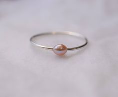 PLEASE CHECK ANNOUNCEMENTS FOR PROCESSING TIMES :) The size of the Freshwater pearl is 3.5x3mm. The pearls are smooth and high high luster. Overtones of the pink freshwater pearl my vary: LIGHT PINK to PINK to LIGHT PURPLE PINK We only use real pearls in all of our jewelry. If you are looking for something DELICATE and DAINTY.. this is for you! Please keep in mind that this item is unique and handmade. The band can expand or bend overtime due to use. The wire you can choose from is sterling silv Minimalist Adjustable Pink Stackable Rings, Minimalist Pink Rings For Everyday Wear, Minimalist Pink Rings For Everyday, Minimalist Everyday Pink Rings, Pink Minimalist Midi Rings, Minimalist Pink Stackable Rings For Everyday, Minimalist Pearl Stackable Rings, Minimalist Pearl Stackable Rings As A Gift, Freshwater Pearl Ring