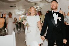 a bride and groom walking down the aisle after their wedding ceremony with confetti in hand