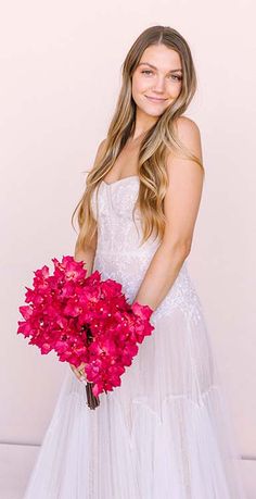 a beautiful young woman holding a bouquet of flowers