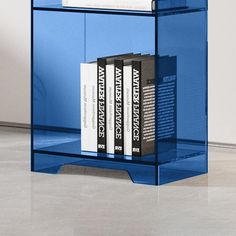 a blue book shelf with three books on it