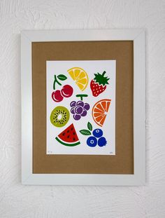 a white framed artwork with fruit on it