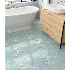 a white bath tub sitting next to a wooden cabinet in a bathroom with blue tiles on the floor