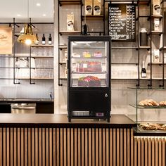 a bakery with lots of food on display behind the counter and shelves filled with pastries