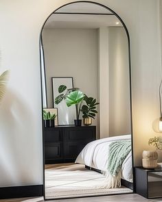 a large mirror sitting on top of a floor next to a bed