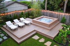 an outdoor hot tub in the middle of a yard with lawn chairs and lights on it