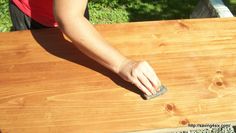 a person sanding wood with a sponge on the top and one hand holding a piece of wood