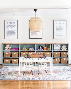 a dining room table and chairs with baskets on the wall above it in front of two bookshelves