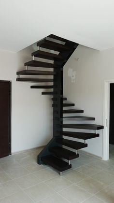 a black spiral staircase in an empty room