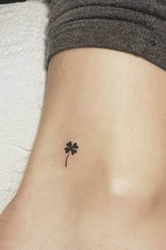 a small four leaf clover tattoo on the side of a woman's stomach,