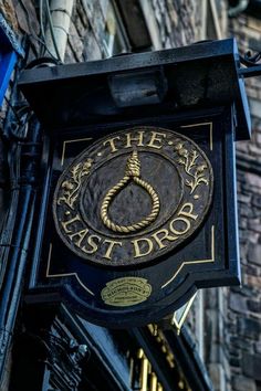 the sign for the east drop restaurant hangs from the side of an old brick building