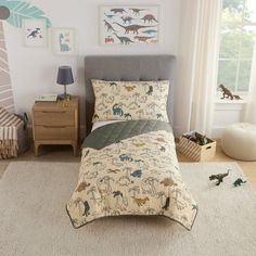 a child's bedroom with dinosaur bedding and toys