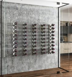 a wine rack with many bottles in it on the wall next to a wooden floor