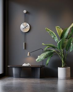 a clock on the wall next to a potted plant and a table with a lamp