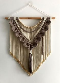 a white wall hanging with some tassels on it