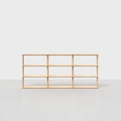 an empty wooden shelf sitting on top of a white floor