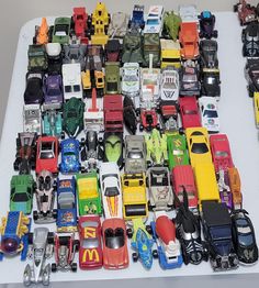 a table topped with lots of toy cars and trucks on top of eachother