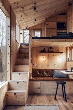 the interior of a tiny cabin with stairs leading up to the loft bed and desk