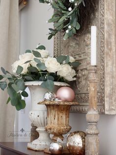 a vase filled with flowers and eggs on top of a table next to a candle