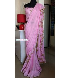 Color : Pink Fabric - Chinon This Ruffled Saree has beautiful Crystal Scallop trim at the hemline. Length of Saree 48 inches. Blouse : Pink Emroidered Net with Silk Lining The blouse and underskirt/petticoat will be stitched as per the measurements provided IF YOU WISH TO PURCHASE THIS WE CAN SEND A VIDEO ON YOUR WHATSAPP NUMBER FOR BETTER UNDERSTANDING OF THE SAREE Fabric Care : Dry Clean Only Disclaimer: The actual color of the product might slightly differ from the image due to photographic l Pink Georgette Pre-draped Saree With Embroidered Border, Reception Saree With Embroidered Border In Pink, Elegant Pre-draped Saree With Embroidered Border For Wedding, Wedding Anarkali Style Pre-draped Saree With Embroidered Border, Fitted Georgette Sharara With Embroidered Border, Fitted Georgette Lehenga With Embroidered Border, Fitted Pre-draped Saree With Embroidered Border For Party, Fitted Pre-draped Saree With Gota Work For Wedding, Elegant Pink Blouse Piece With Embroidered Border